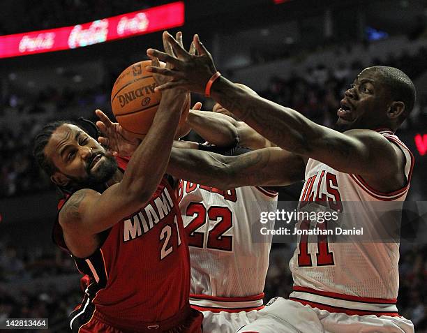 Ronny Turiaf of the Miami Heat battles for a rebound with Taj Gibson and Ronnie Brewer of the Chicago Bulls at the United Center on April 12, 2012 in...