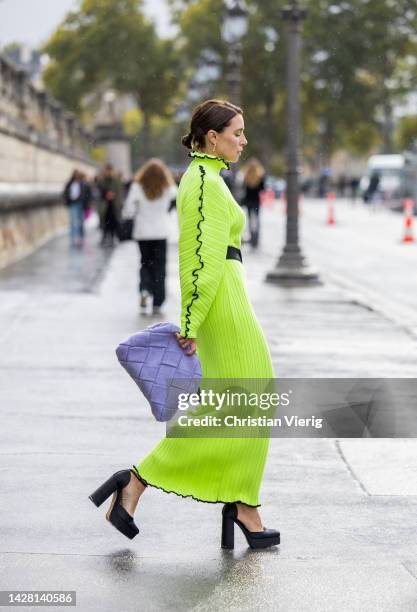 Olga Naumova wears neon yellow dress Jamemme, black belt, rose bag Jamemme X Knitel Wear, earrings Bevza, shoes Zara outside Dior during Paris...