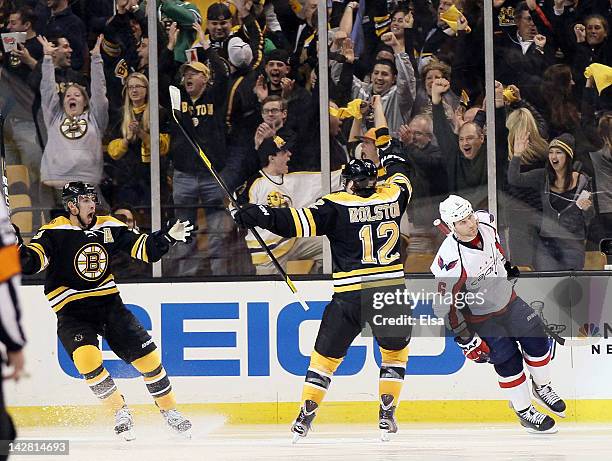 Chris Kelly of the Boston Bruins celebrates his game winning goal in overtime with Brian Rolston as Dennis Wideman of the Washington Capitals skates...