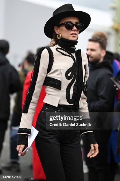 Guest is seen wearing a black and white Dior jacket, black jeans and black hat with black sunglasses outside the Dior show during Paris Fashion Week...