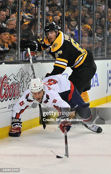 Dennis Wideman of the Washington Capitals fights for the puck against Benoit Pouliot of the Boston Bruins in Game One of the Eastern Conference...