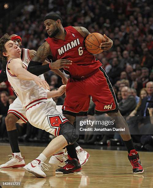 LeBron James of the Miami Heat hits Omer Asik of the Chicago Bulls in the chest with his elbow at the United Center on April 12, 2012 in Chicago,...