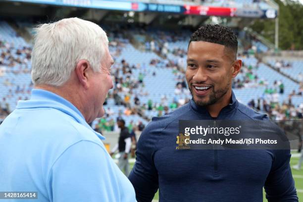 Head coaches Marcus Freeman of the University Notre Dame and Mack Brown of the University North Carolina meet at midfield before a game between Notre...