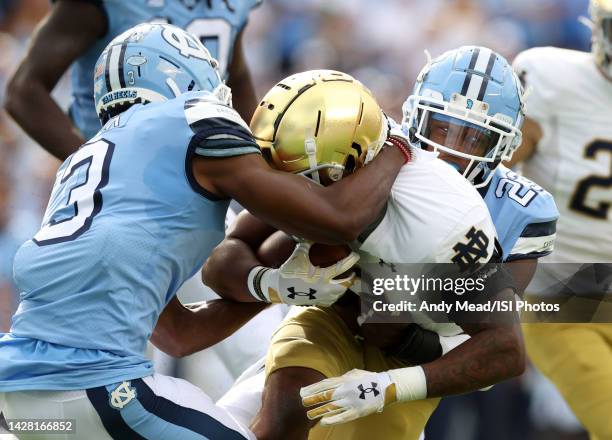 Logan Diggs of the University Notre Dame is tackled by Storm Duck and Power Echols of the University North Carolina during a game between Notre Dame...