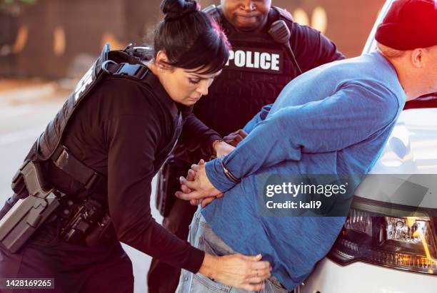 policewoman and partner arresting man - arrest warrant stock pictures, royalty-free photos & images