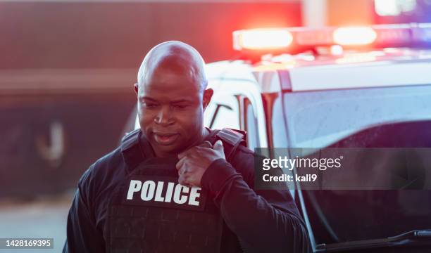 真剣なアフリカ系アメリカ人の警察官、ライトが点滅 - 警察官の制服 ストックフォトと画像