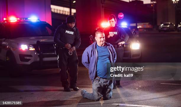 two police officers arresting a suspect at night - hands behind back stock pictures, royalty-free photos & images