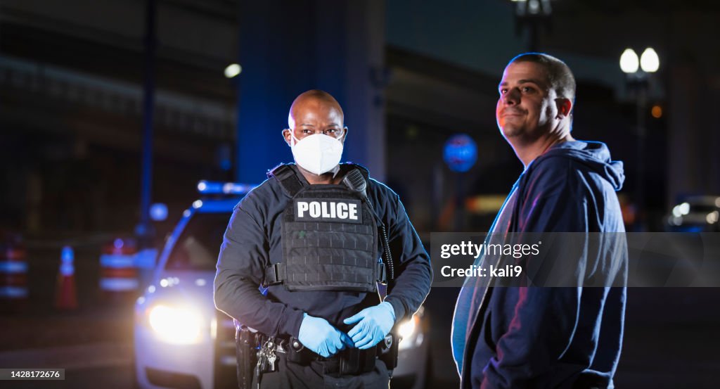 Policial afro-americano à noite com máscara facial