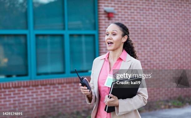 school administrator or teacher outside building - walkie talkie imagens e fotografias de stock