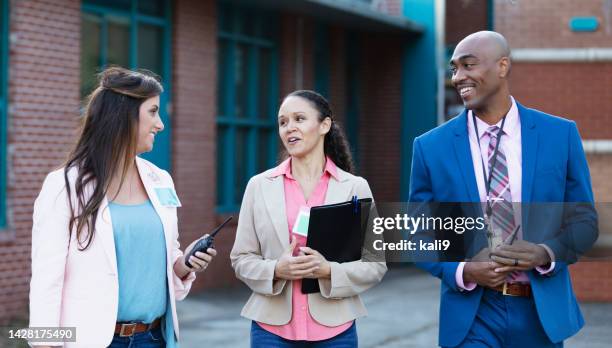 teachers and principal talking outside school building - teacher with folder stock pictures, royalty-free photos & images