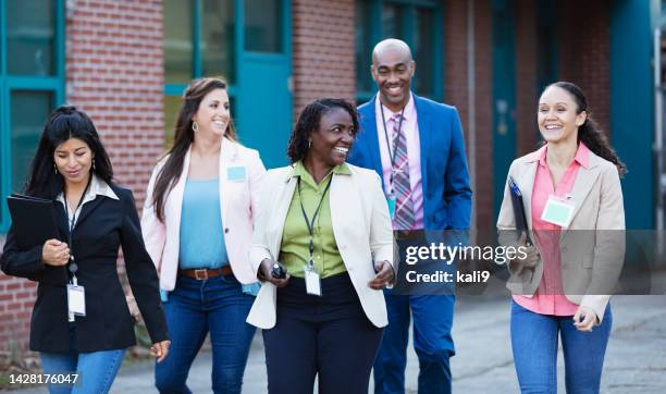 group of teachers walking together outside school - school principal stock pictures, royalty-free photos & images