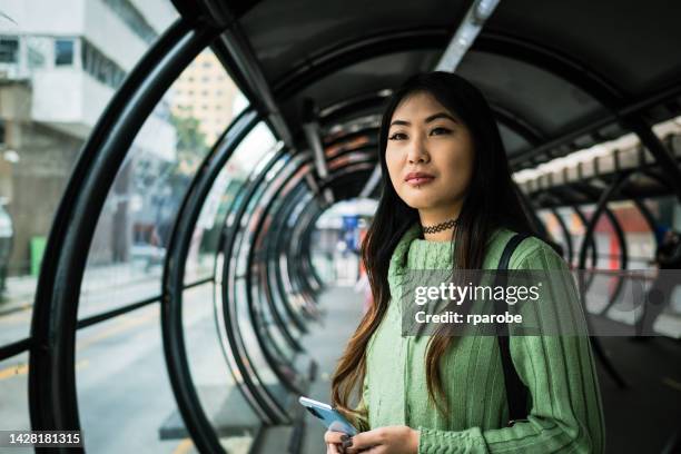 japanese woman waiting for bus at the station - southern brazil stock pictures, royalty-free photos & images