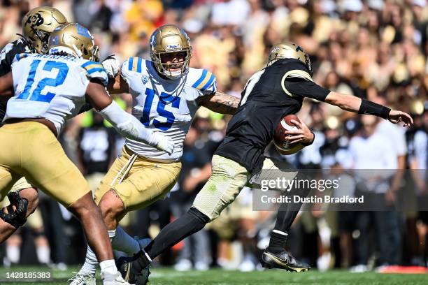 Quarterback Owen McCown of the Colorado Buffaloes carries the ball as linebacker Laiatu Latu of the UCLA Bruins covers the play in the third quarter...