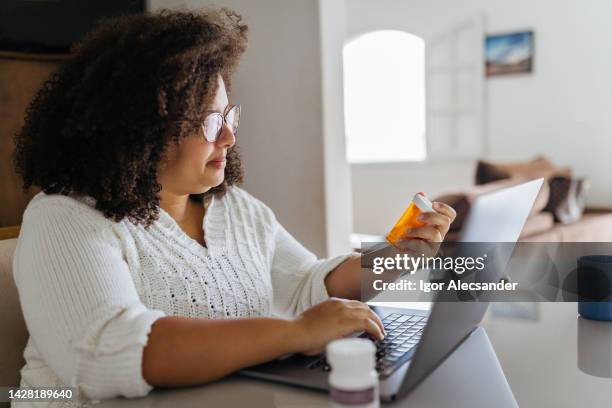 woman ordering medicine online on laptop - order online stock pictures, royalty-free photos & images