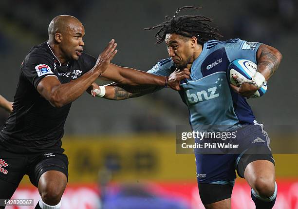 Ma'a Nonu of the Blues fends off JP Pietersen of the Sharks during the round eight Super Rugby match between the Blues and the Sharks at Eden Park on...