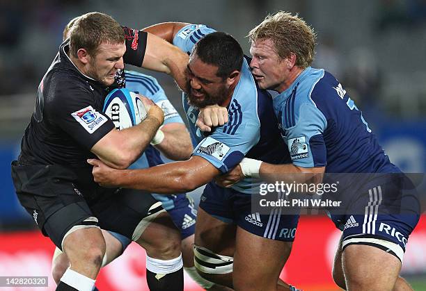 Jean Deysel of the Sharks is tackled by Charlie Faumuina and Daniel Braid of the Blues during the round eight Super Rugby match between the Blues and...