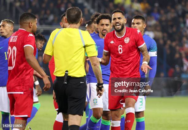 Dylan Bronn of Tunisia argues with Referee Ruddy Buquet of France after receiving a red card during the international friendly football match between...