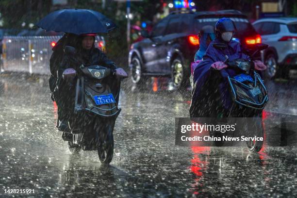 Local residents ride on the street against heavy rain on September 27, 2022 in Haikou, Hainan Province of China. Noru, the 16th named storm of the...