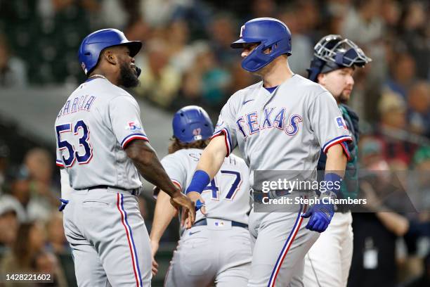 Josh Jung of the Texas Rangers celebrates his three-run home run with Adolis Garcia in the eighth inning against the Seattle Mariners at T-Mobile...