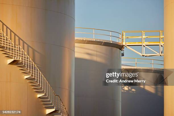 metal staircase walkway, fuel storage tank at dusk - silo tank stock-fotos und bilder