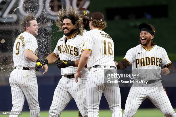 Jake Cronenworth, Brandon Dixon, Luis Campusano congratulate Jorge Alfaro of the San Diego Padres after he drew a walk with bases loaded scoring the...