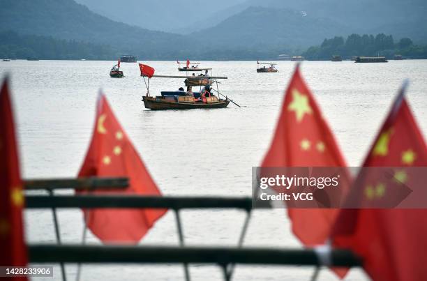 Chinese national flags fly on the sightseeing boats at West Lake scenic spot to welcome the upcoming China's National Day on September 27, 2022 in...