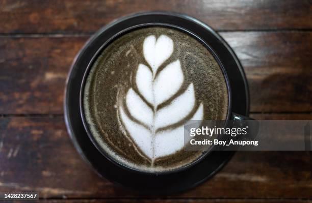 a trendy cup of goth latte or charcoal latte on wooden table. - goth boy stock-fotos und bilder