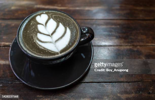 a cup of goth latte or charcoal latte on wooden table. - goth boy stock-fotos und bilder
