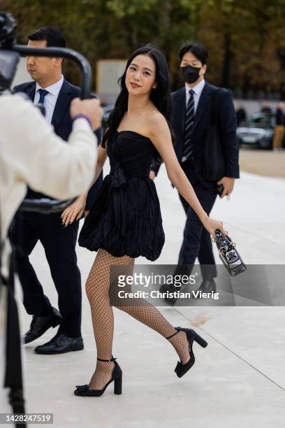 Jisoo wears black off shoulder dress, net tights, black white bag, heels outside Dior during Paris Fashion Week - Womenswear Spring/Summer 2023 : Day...