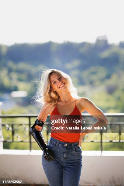 beautiful slim woman with a prosthetic arm in the park in the summer. - artificial arm stock pictures, royalty-free photos & images