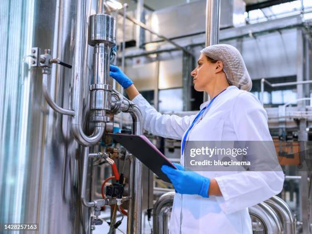 female engineer working on maintenance in bottling plant - bottling plant stock pictures, royalty-free photos & images