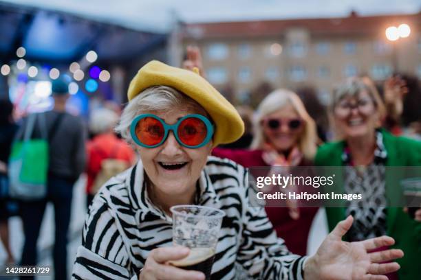 cheerful senior friends enjoying outdoor night concert in city. - break photos et images de collection