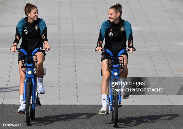 Chantal Hagel and Sarai Linder, players of Germany's women's national football team, arrive on bikes for a training session at the team's preparation...