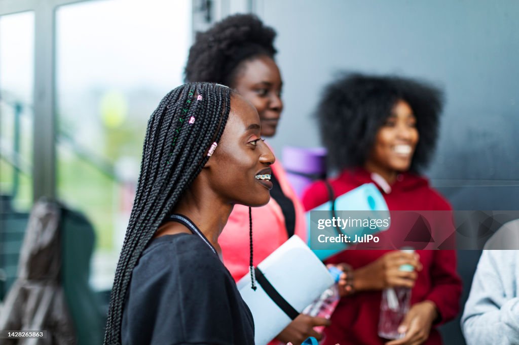 Young Black women talking outdoors after sport training at overcast