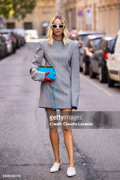 Candela Pelizza is seen wearing grey dress, red gloves, blue bag and sunglasses outside the Sportmax show during the Milan Fashion Week - Womenswear...