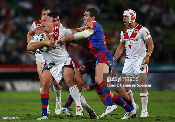 Michael Weyman of the Dragons is tackled during the round seven NRL match between the St George Illawarra Dragons and the Newcastle Knights at WIN...