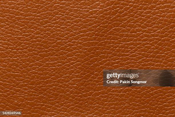 brown leather and a textured background. - cowhide stock pictures, royalty-free photos & images