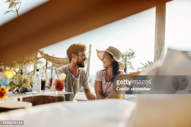 happy couple talking while relaxing in a beach café. - cafe at beach bildbanksfoton och bilder
