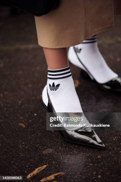 Guest wearing white Adidas socks, and black Prada shoes outside Victoria/Tomas, during Paris Fashion Week - Womenswear Spring/Summer 2023, on...