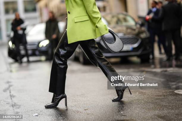 Alice Barbier wears a green blazer jacket, black shiny leather flared pants, a black shiny leather with embroidered silver rhinestones handbag from...