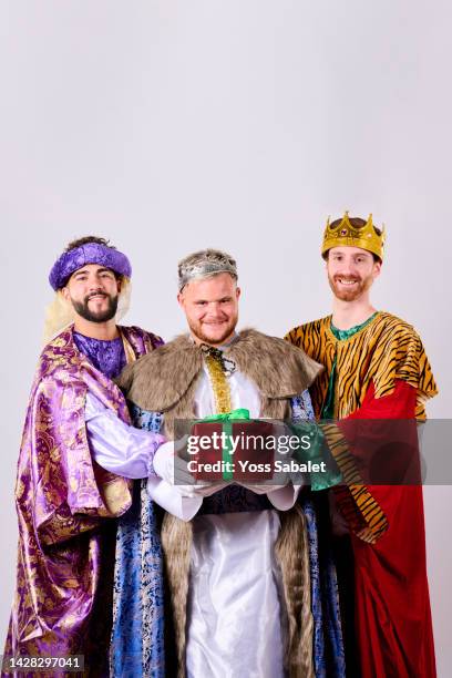 three smiling kings with a gift in their hands on three kings day - los tres reyes magos fotos fotografías e imágenes de stock