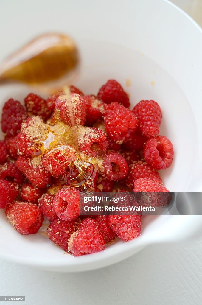 Himbeeren with honey in bowl