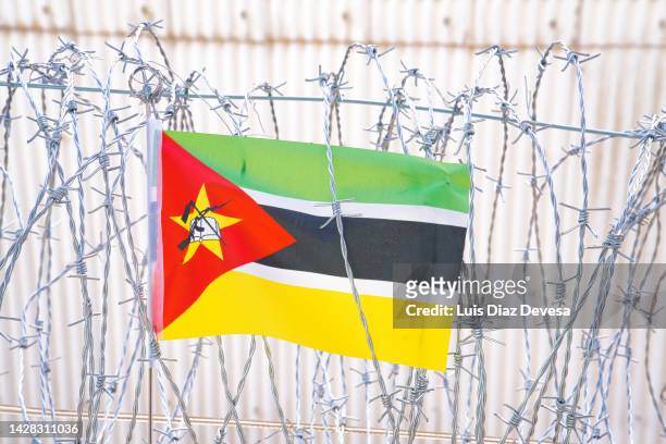 flag of mozambique on barbed wire - mozambique war stock pictures, royalty-free photos & images