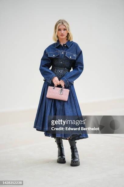 Elsa Hosk wears a navy blue denim shirt / pleated long dress from Dior, a black shiny leather mesh corset from Dior, a pale pink shiny leather Lady...