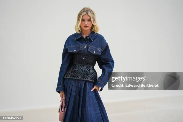 Elsa Hosk wears a navy blue denim shirt / pleated long dress from Dior, a black shiny leather mesh corset from Dior, a pale pink shiny leather Lady...