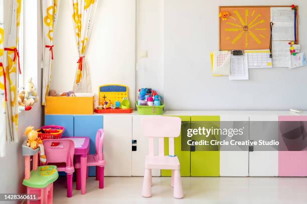 kindergarten-klassenzimmer mit tisch und bunten stühlen - kinderzimmer stock-fotos und bilder