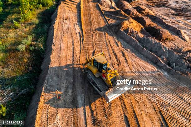 bulldozer is leveling the ground at the construction site. aerial view - bulldozer stock pictures, royalty-free photos & images