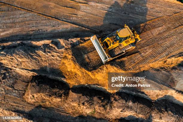 bulldozer is leveling the ground at the construction site. aerial view - construction machinery stock pictures, royalty-free photos & images