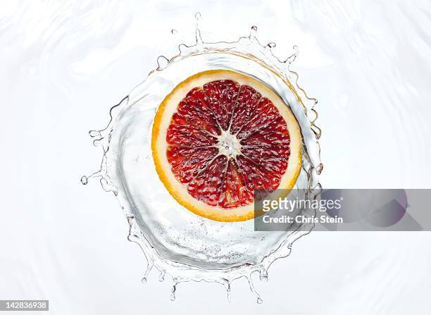 slice of blood orange splash - blood orange stock pictures, royalty-free photos & images