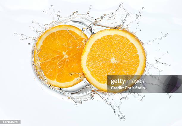 orange slices splash - orange slice stock-fotos und bilder